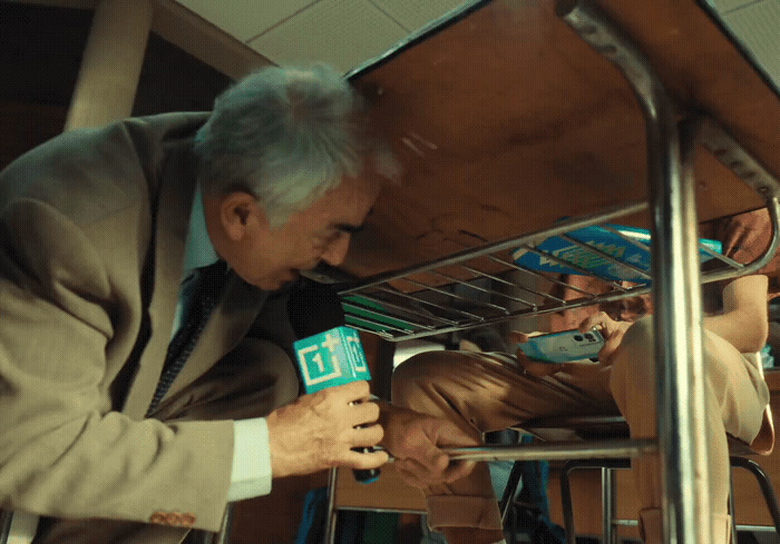 a man in a suit and tie looking at something on a shelf