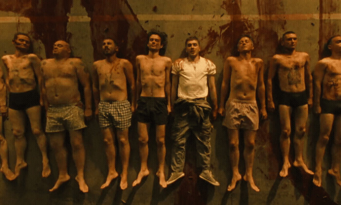 a man standing in front of a group of naked men