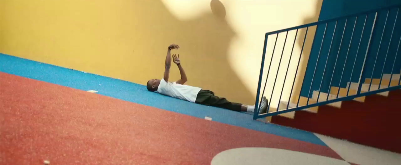 a man laying on the ground in front of a stair case