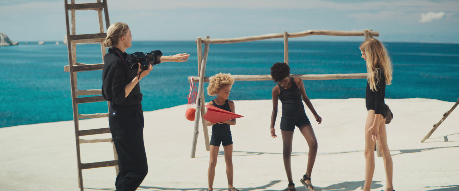 a group of women standing on top of a sandy beach