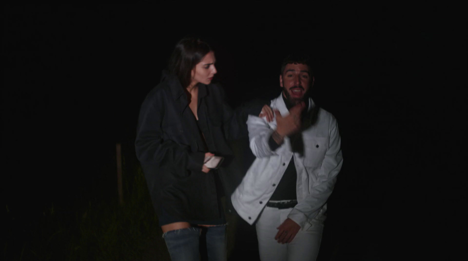 a man standing next to a woman in the dark