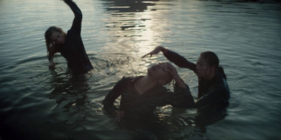 two women are in the water with their hands in the air