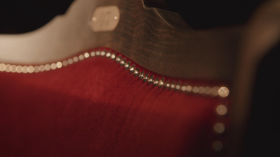 a close up of a red cloth with a metal rivet