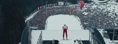 a man standing on top of a snow covered ski slope