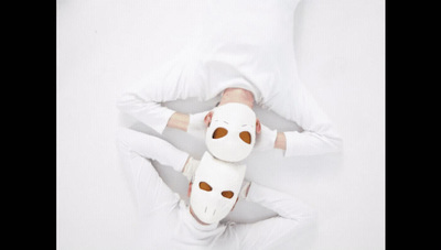 a person in white is laying down with a mask on