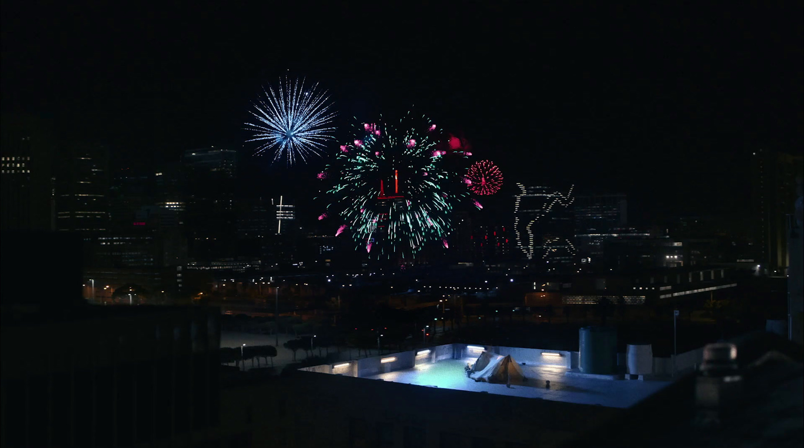 fireworks are lit up in the night sky over a city