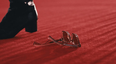 a pair of sunglasses laying on a red carpet