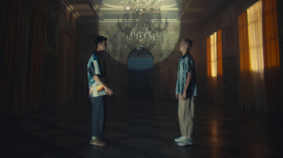 two young men standing in a dark hallway