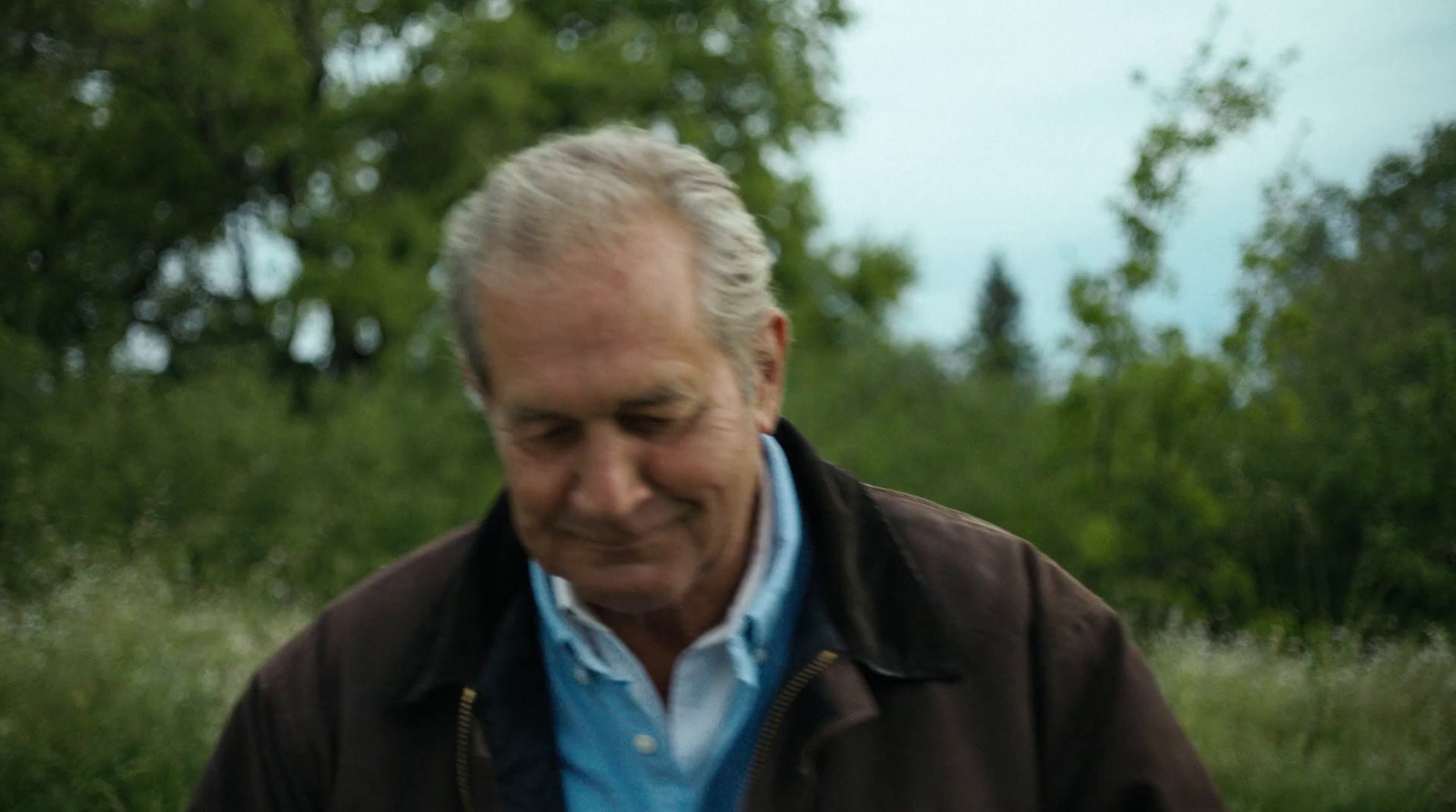 a man in a brown jacket holding a white frisbee