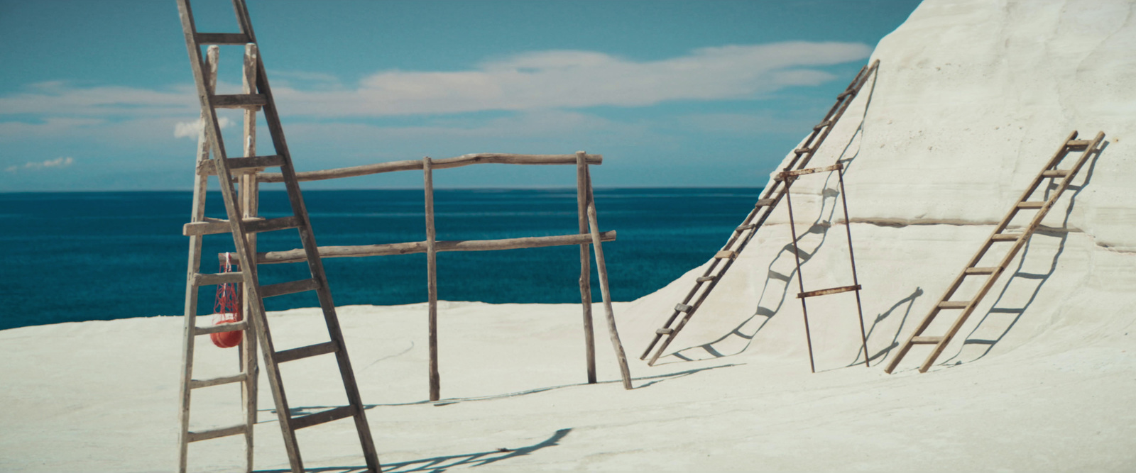 a ladder leaning against a wall on a beach