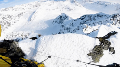 a man riding skis down the side of a snow covered slope