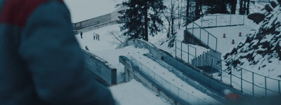 a man standing on a snow covered slope next to a forest