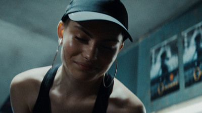 a woman wearing a hat looking down at her cell phone