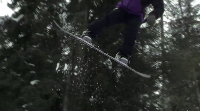 a man flying through the air while riding a snowboard