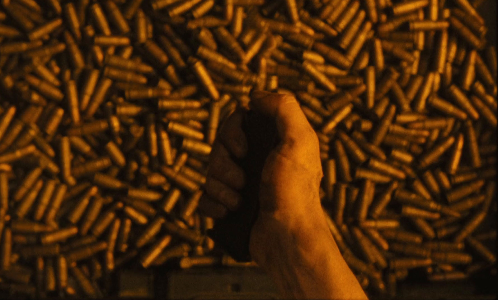 a hand holding a bunch of bullet shells