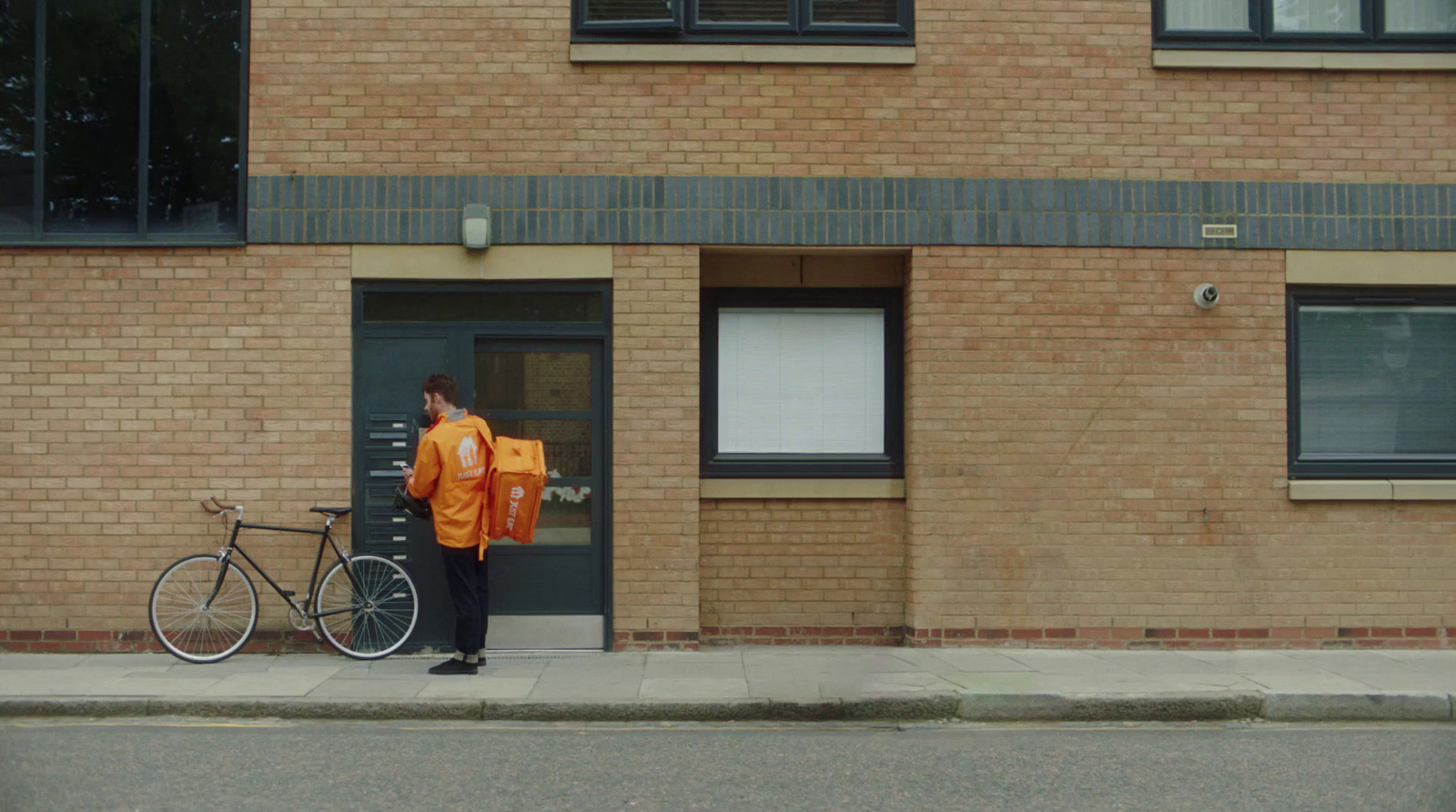 a man standing next to a bike on a sidewalk