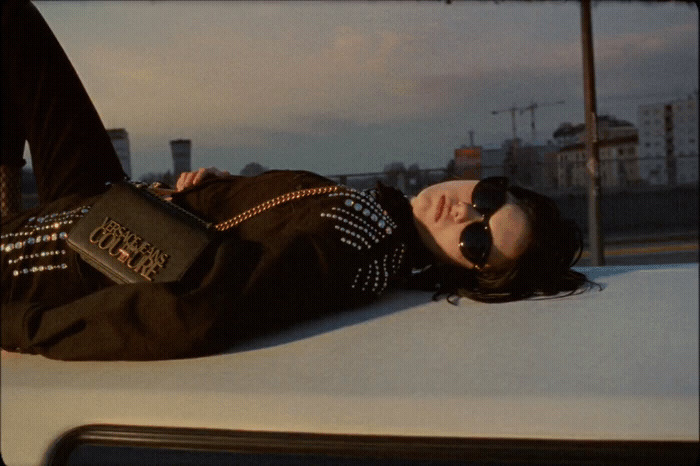 a woman laying on top of a white car