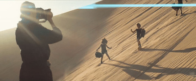 a group of people standing on top of a sandy hill