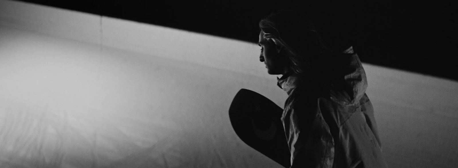 a black and white photo of a person holding a skateboard