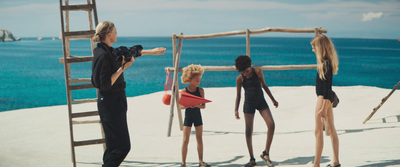 a group of women standing on top of a sandy beach