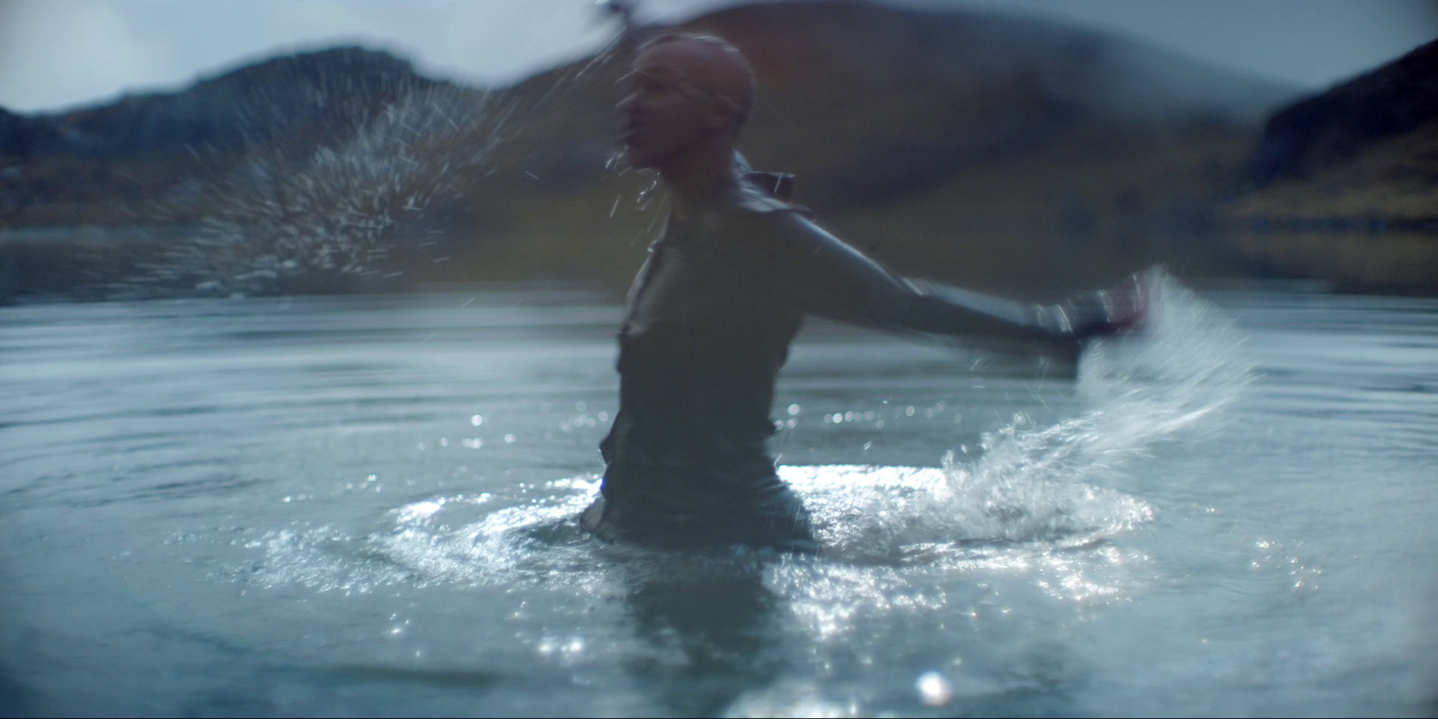 a woman is wading in a body of water