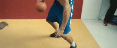 a young man holding a basketball on top of a basketball court