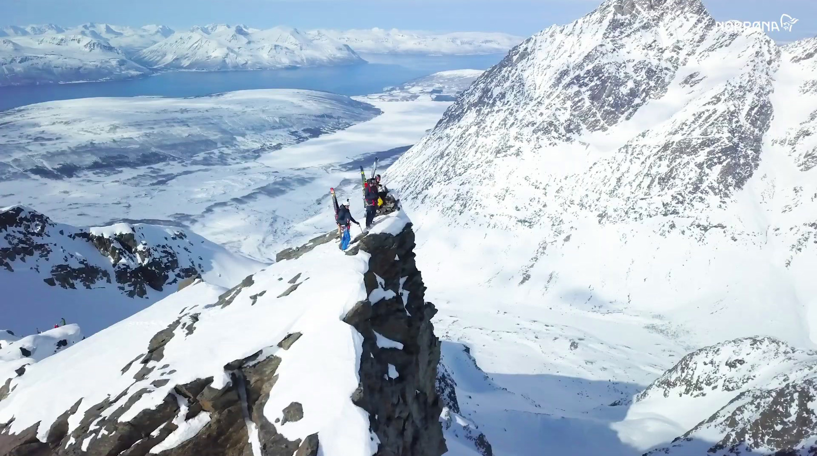 a group of people standing on top of a snow covered mountain