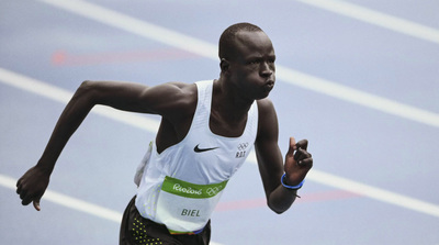 a man running on a track in a white shirt