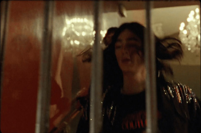 a woman standing behind bars in a jail cell