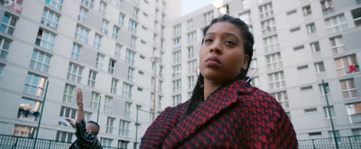 a woman standing in front of a tall building