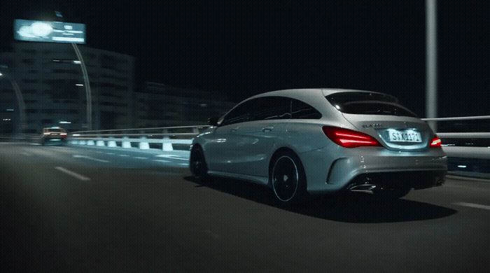 a white car driving down a highway at night