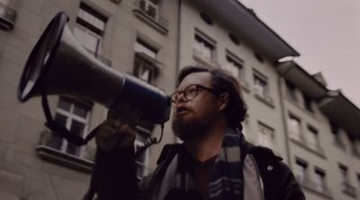 a man holding a megaphone in front of a building