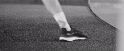 a black and white photo of a person's foot on a tennis court