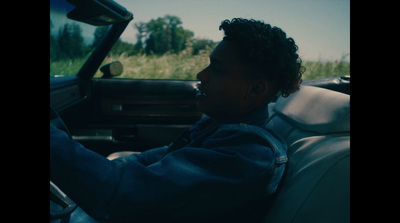 a man driving a car in a grassy field