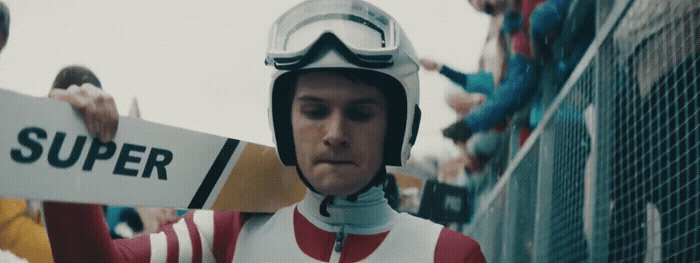 a man wearing a helmet and holding a sign