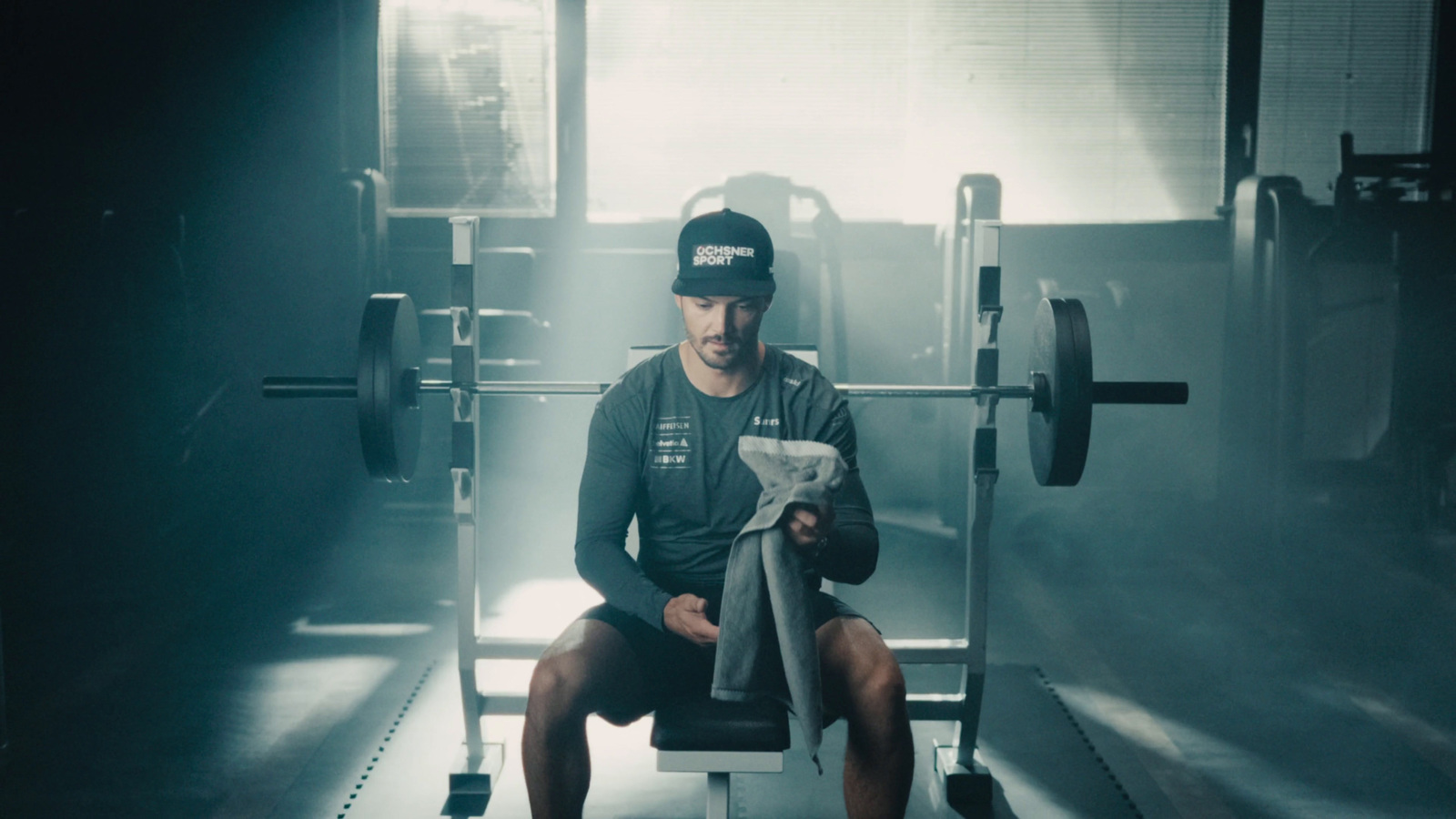 a man sitting on top of a bench in a gym