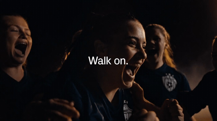 a group of people singing together with the words walk on