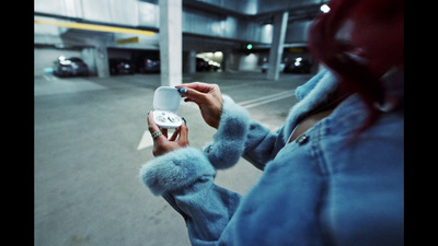 a woman in a parking garage holding a cell phone