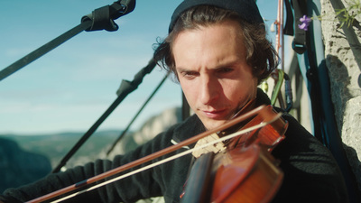 a man playing a violin on a bridge