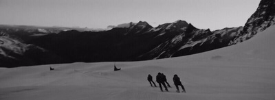 a group of people riding skis down a snow covered slope