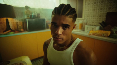 a man with a mohawk standing in a kitchen