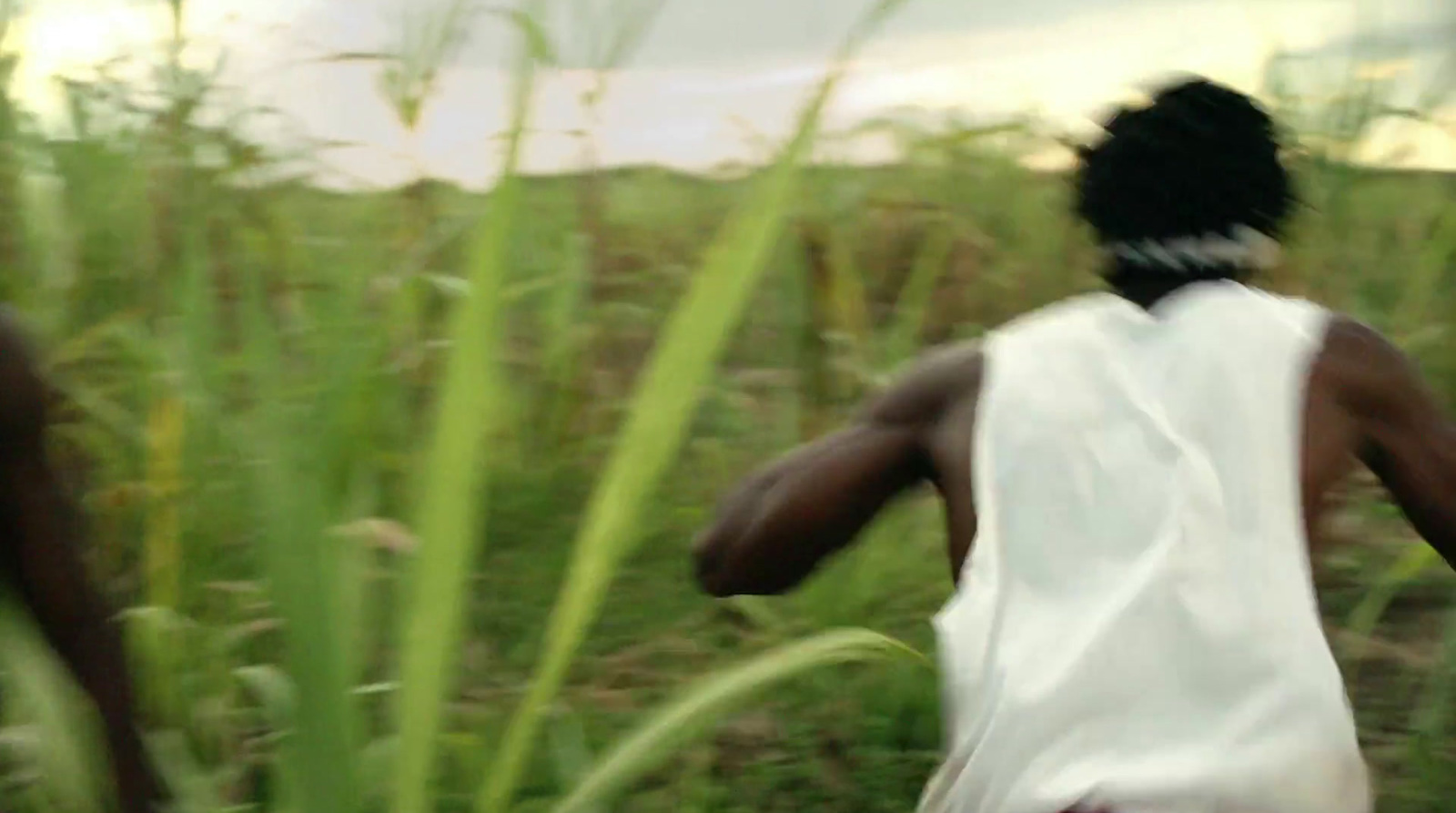 a woman in a white dress running through a field