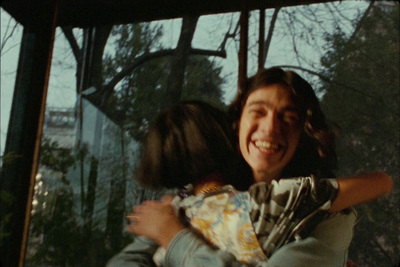 a man and a woman hugging each other in front of a window