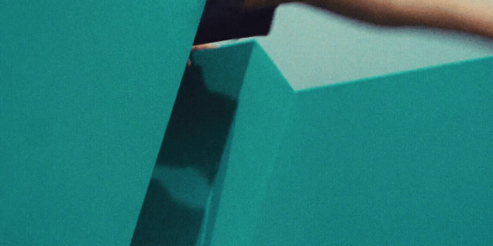 a hand reaching into a blue box with something in it