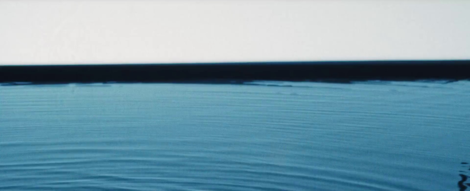 a white boat floating on top of a body of water