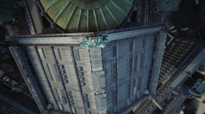 an aerial view of a tall building with a green roof