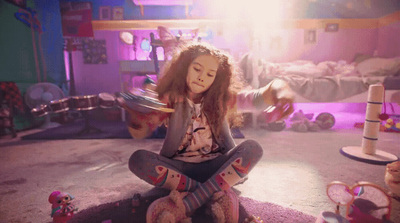 a young girl sitting on the floor with her feet on a skateboard