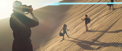 a group of people standing on top of a sandy hill