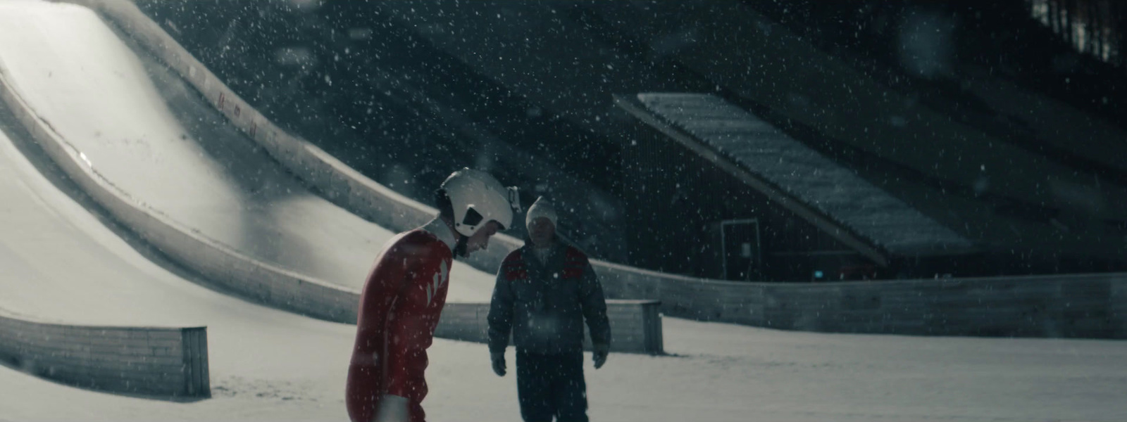 a couple of people standing on top of a snow covered slope