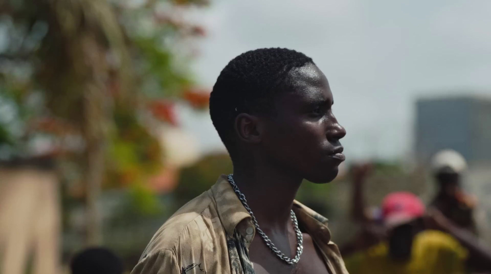 a young man with a necklace on his neck